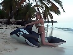 Riding an inflatable whale at the beach - nonpop
